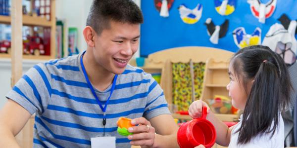 Teacher engaged in dramatic play with a preschooler
