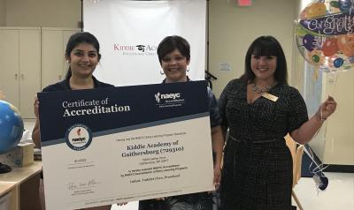 Kiddie Academy staff and NAEYC Accreditation team pose for a picture with accreditation certificate.