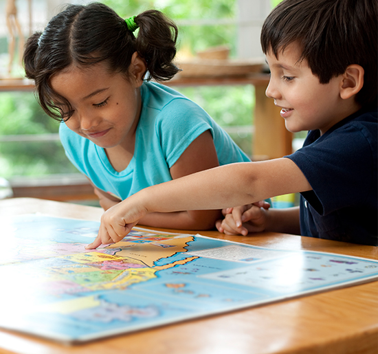 A young boy and girl looking at a map on a table