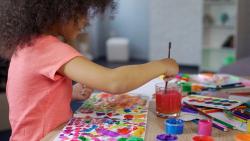 a young girl painting a picture